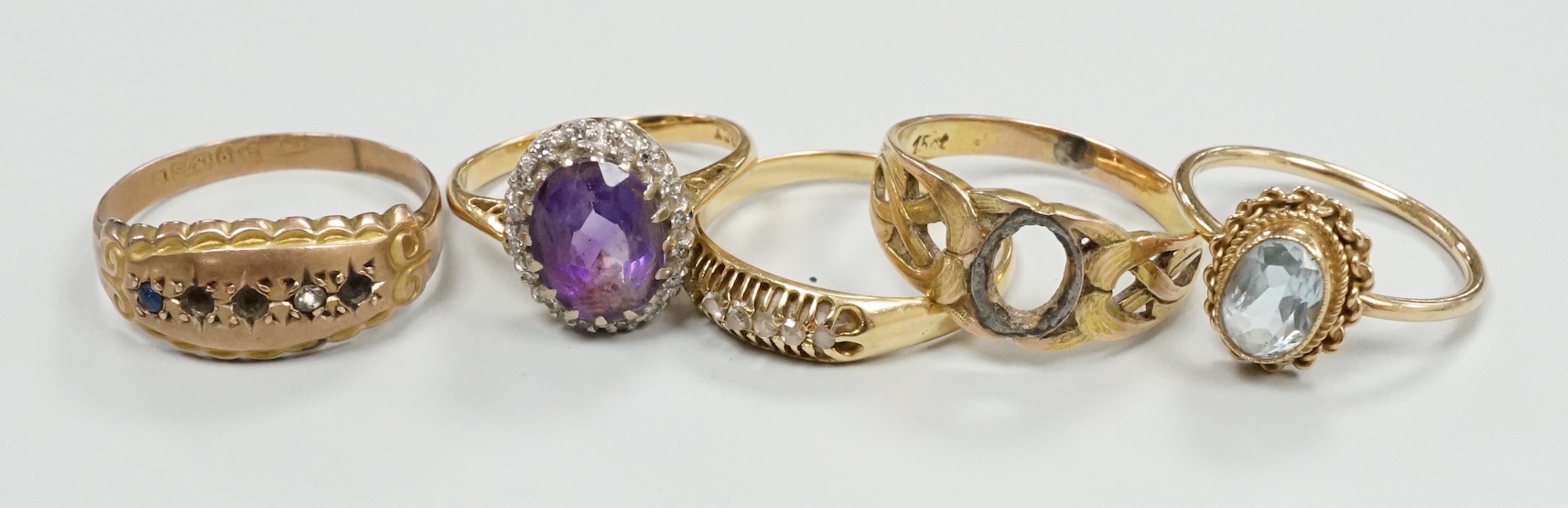 An 18ct, amethyst and diamond set oval cluster ring, size K and four other rings including gem set.
